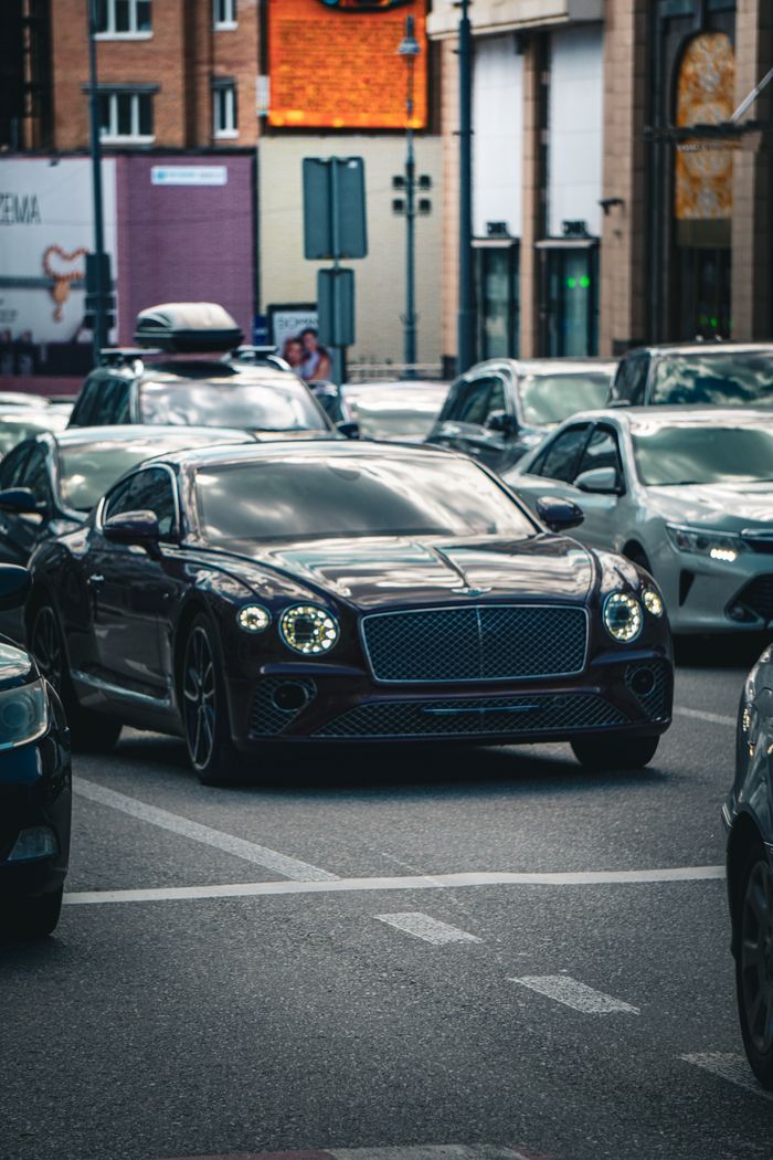 A luxury Bentley navigating through busy Kyiv traffic showcasing urban life.